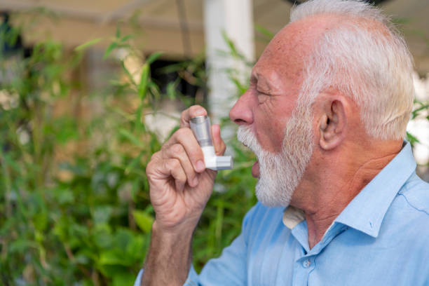 istock Mature Businessman Using Asthma Inhaler 1193066397