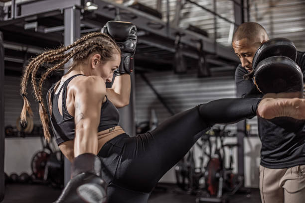 istock Female fighter and male coach during a workout 1193067685