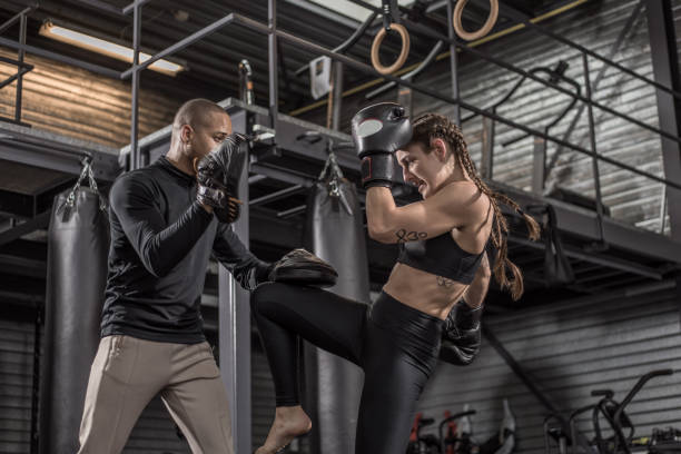 istock Female fighter and male coach during a workout 1193070557