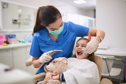 Mujer dentista que examina a la paciente dental en el procedimiento dental. photo
