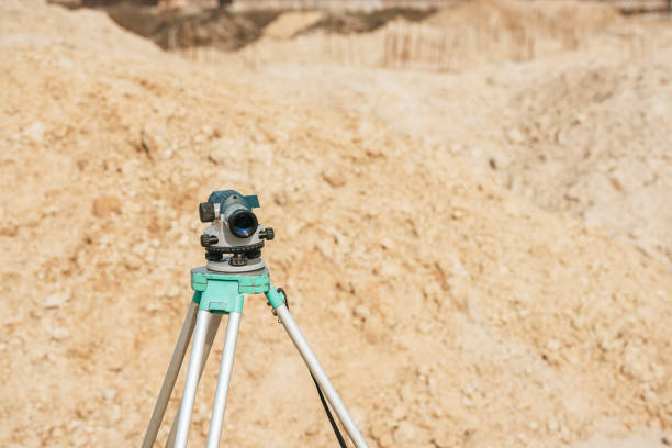 istock Digital level on tripod with sand mounds on background 1193074106