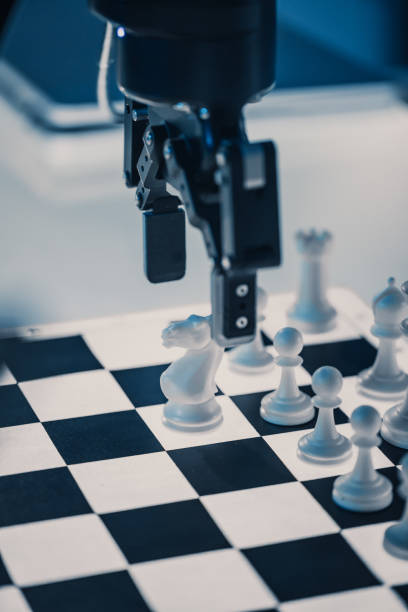 de cerca disparo vertical de inteligencia artificial que opera un brazo robótico futurista en un juego de ajedrez contra un humano. robot mueve un peón. están en un laboratorio de investigación moderna de alta tecnología. - chess pawn red blue leisure games fotografías e imágenes de stock