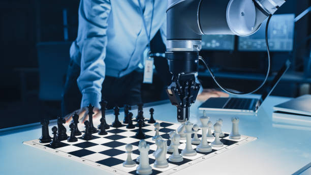 disparo de cerca de una inteligencia artificial que opera un brazo robótico futurista en un juego de ajedrez contra un humano. robot mueve un peón. están en un laboratorio de investigación moderna de alta tecnología. - chess pawn red blue leisure games fotografías e imágenes de stock