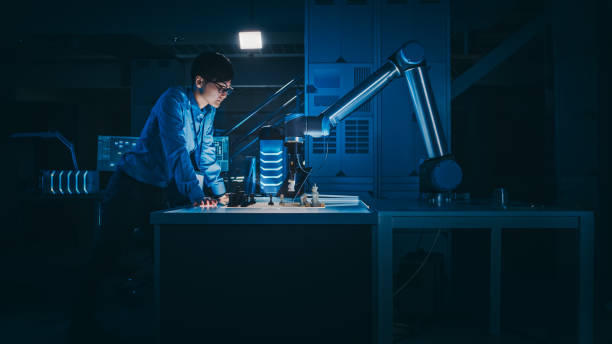 el ingeniero de desarrollo japonés está probando una interfaz de inteligencia artificial jugando ajedrez con un brazo robótico futurista. están en un laboratorio de investigación moderna de alta tecnología con poca luz clave. - chess pawn red blue leisure games fotografías e imágenes de stock