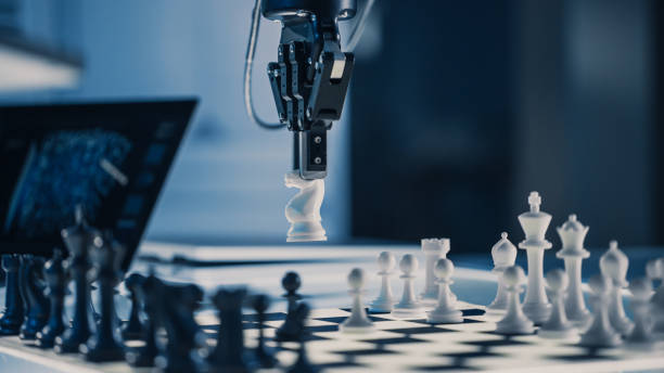 istock Close Up Vertical Shot of Artificial Intelligence Operating a Futuristic Robotic Arm in a Game of Chess. Robot Moves a Knight. High Tech Modern Research Laboratory. 1193074258