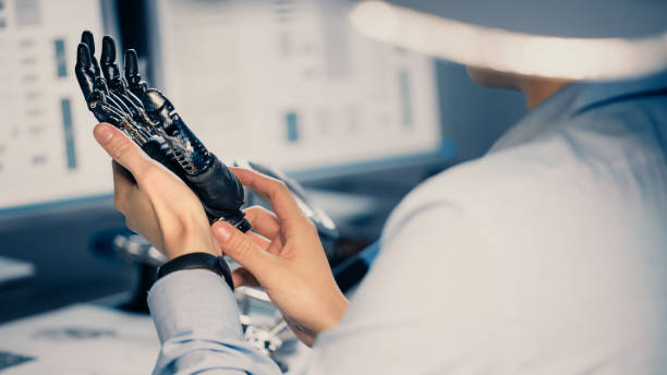 istock Close Up of a Futuristic Prosthetic Robot Arm Being Tested by a Professional Development Engineer in a High Tech Research Laboratory with Modern Computer Equipment. 1193074331