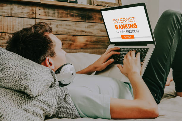 istock Man using a laptop computer to access to internet banking, while rest at home. 1193077046