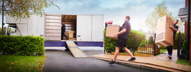 Removal team loading removal truck Removal company helping a family move out of their old home company relocation stock pictures, royalty-free photos & images