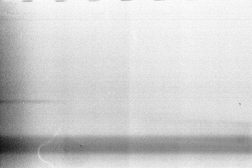 Overexposed noisy film frame with heavy noise, dust and grain. Abstract old film background