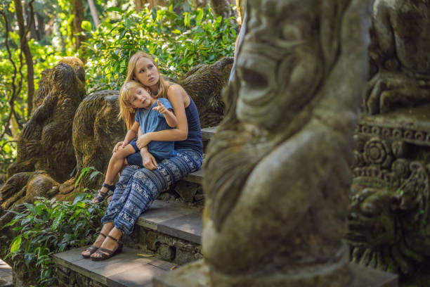 boy tourist discovering ubud, bali indonesia. traveling with children concept - bali sculpture balinese culture human face imagens e fotografias de stock