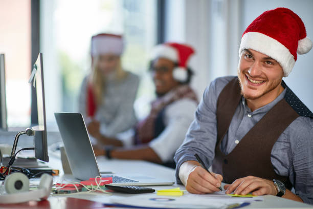 istock Working at Xmas.  Young man in santa hat work in office 1193091596