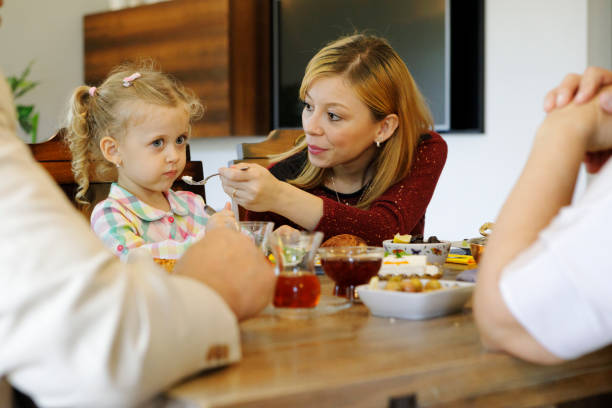 istock Mother Trying to Feed her Daughter 1193092163