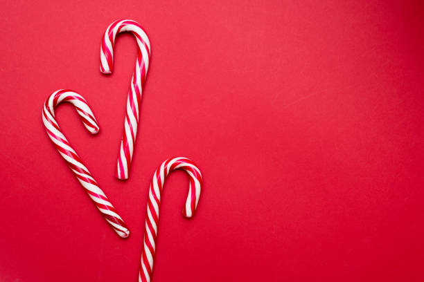 Christmas candy cane on red background with copyspace Christmas candy cane on red background with copyspace candy peppermint christmas mint stock pictures, royalty-free photos & images