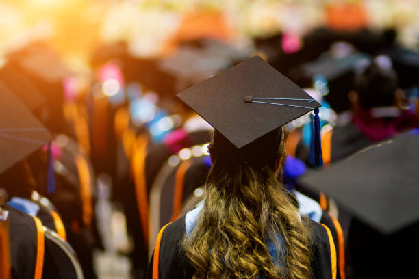 retroguardia dei laureati in fila per il diploma di laurea nella cerimonia di laurea universitaria. - istruzione post secondaria foto e immagini stock