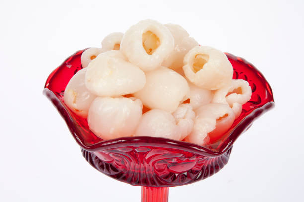 lychees in red bowl on white background