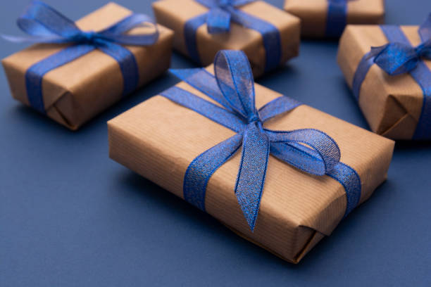 istock Close up gift boxes, presents. Craft paper wrapped gift boxes on blue background. 1193095885
