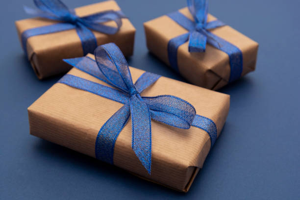 istock Close up gift boxes, presents. Craft paper wrapped gift boxes on blue background. 1193096516