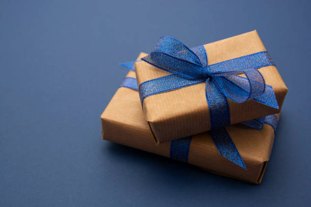 istock Close up gift boxes, presents. Craft paper wrapped gift boxes on blue background. 1193096758