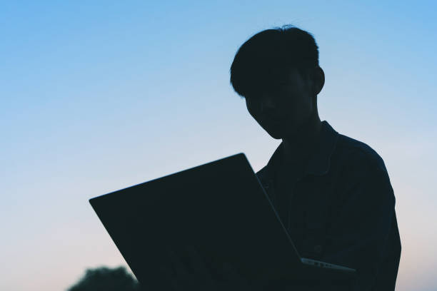 istock Young man using laptop during camping in the morning 1193099770