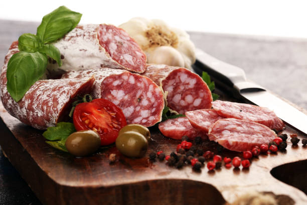 istock thinly sliced salami on a wooden texture on the background. 1193099839