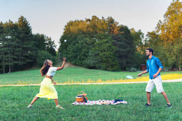 istock Young couple playing badminton on the meadow 1193100613