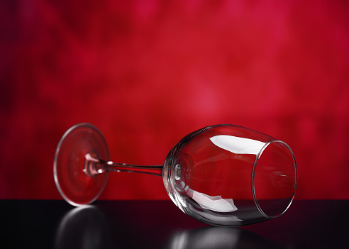 Beautiful glass wine glass on a red background.