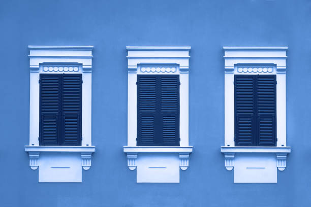 istock tinted blue three wooden window with shutters in white frame on wall 1193104565