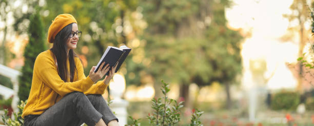 Woman reading book and resting in public park