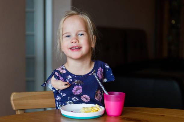 istock Cute young girl with limited hand use eating breakfast 1193113880