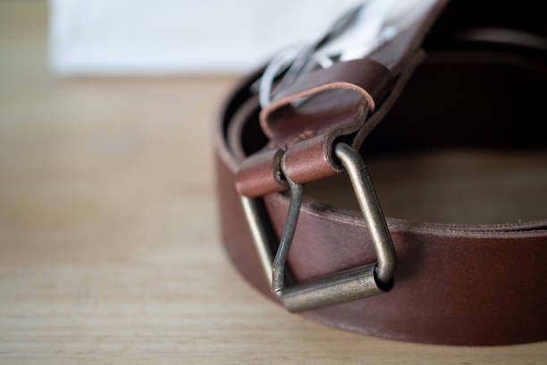 istock New light brown leather belt with a buckle on wood table 1193113912