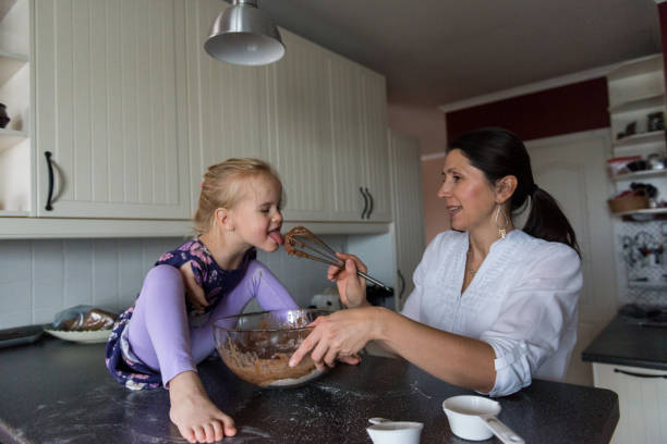 istock Little girl tasting cake batter 1193114087