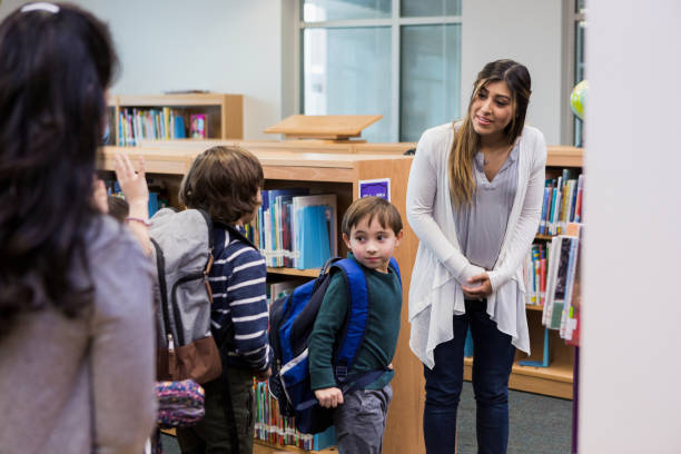 istock Mid adult teacher answers question from unrecognizable student in line 1193114183
