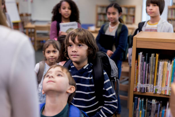 istock Children stand in line to face unrecognizable librarian 1193114238