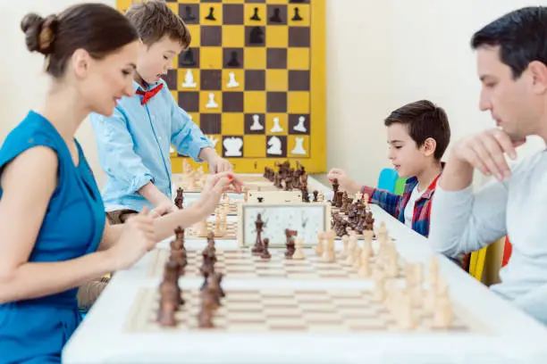 Photo of Family playing chess in tournament room