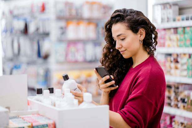 istock Woman using cellphone to scan cosmetic products 1193114352