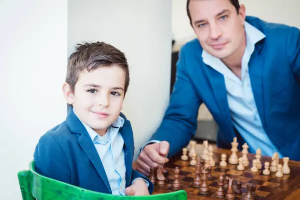 Photo of Father and son playing chess