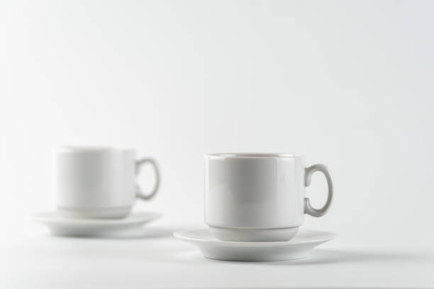 two white empty cups and saucers on a white background. selective focus. - two objects cup saucer isolated imagens e fotografias de stock