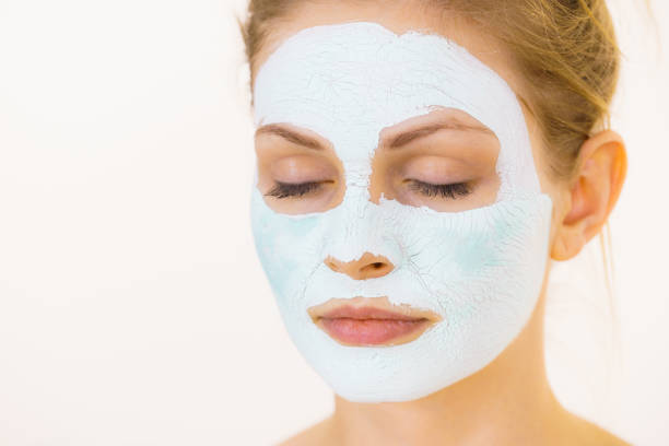 istock Girl with green mud mask on face 1193119843