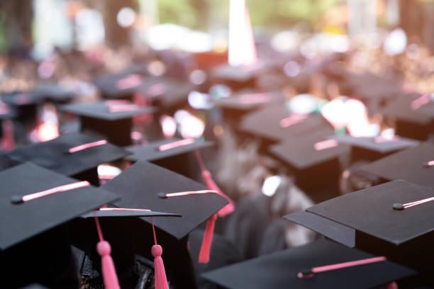 istock Group of Graduates during commencement. Concept education congratulation in University Degree. Graduation Ceremony. focus tassel pink. 1193120575