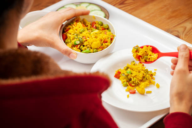 istock Hands serving veg biriyani on plate and having lunch. 1193120629