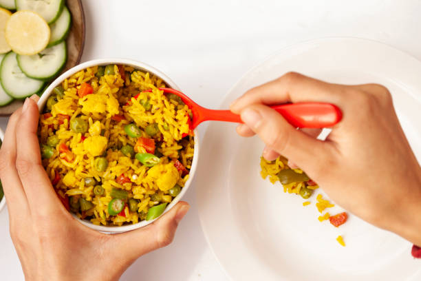istock Hands serving veg biriyani on plate and having lunch. 1193121245