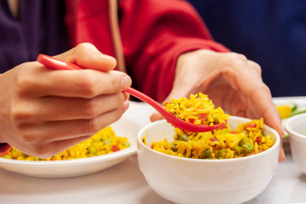 istock Hands serving veg biriyani on plate and having lunch. 1193121289