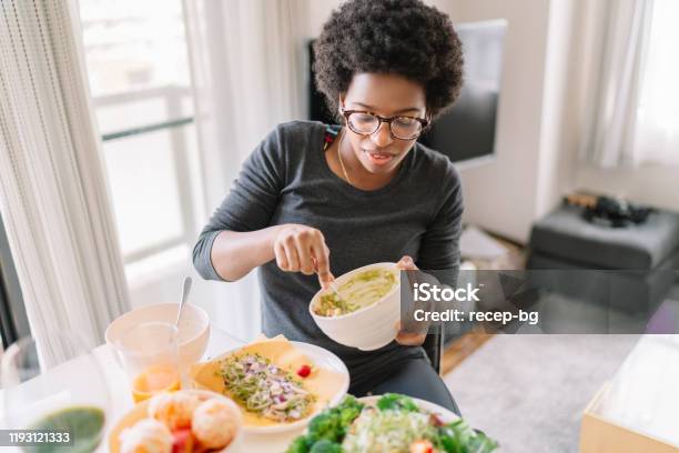 Young Woman Eating Vegan Food At Home Stock Photo - Download Image Now - Eating, Women, One Woman Only