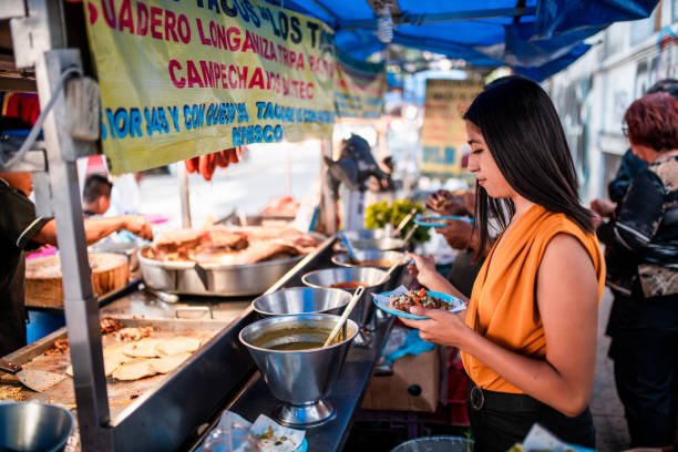Lunch time Young women choosing sauce for her taco mexico street scene stock pictures, royalty-free photos & images