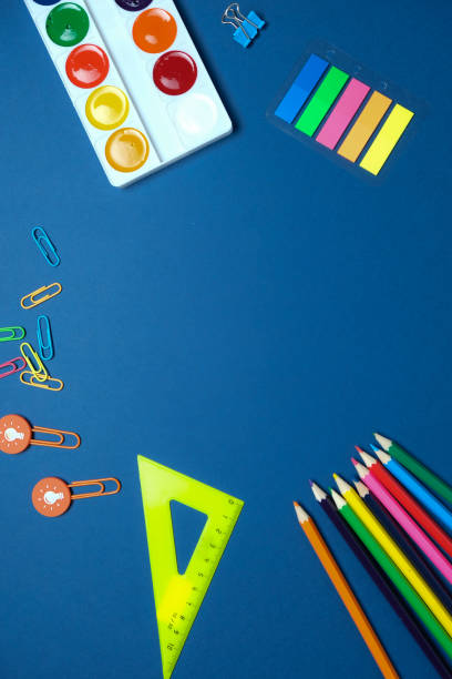 istock Round frame with colorful pencils scissors on blue background, back to school concept 1193121673