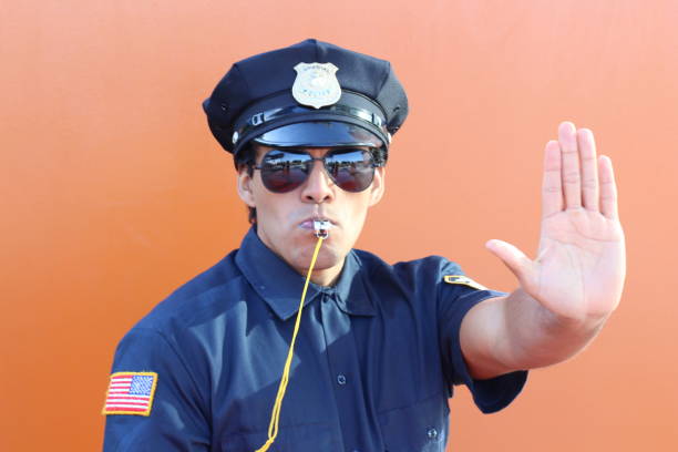 istock Stern police officer blowing a whistle 1193121773