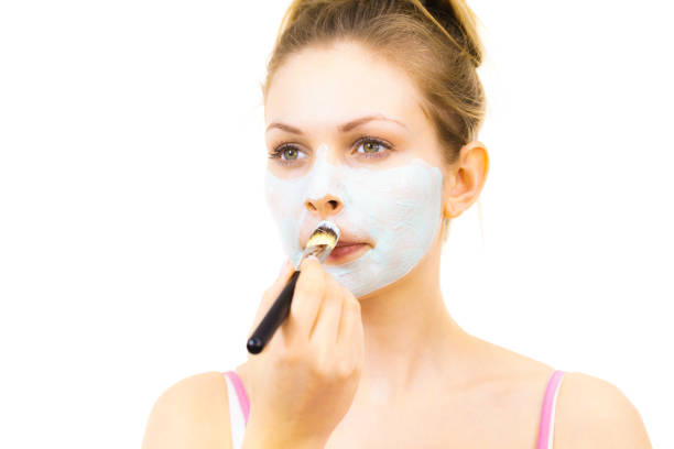 istock Girl apply green mud mask to face 1193121775