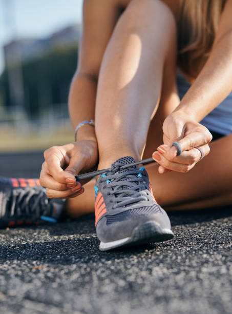 istock woman tying her running shoes before running 1193122385