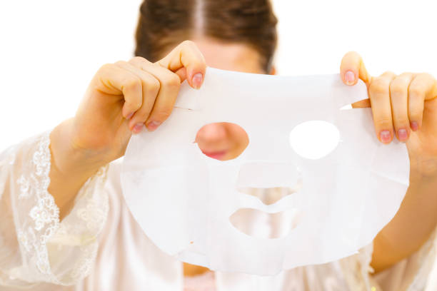 istock Woman applying sheet mask on face 1193124057