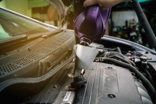 istock Hand refill engine lubricant oil on personal car 1193124595